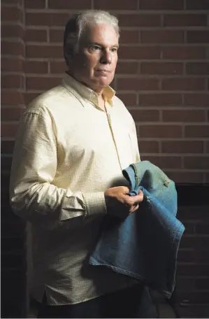  ?? Santiago Mejia / The Chronicle ?? Howard Green, at home in Los Gatos, holds the pants he was wearing when wounded during the massacre. The pants show three bullet holes and still have bloodstain­s.