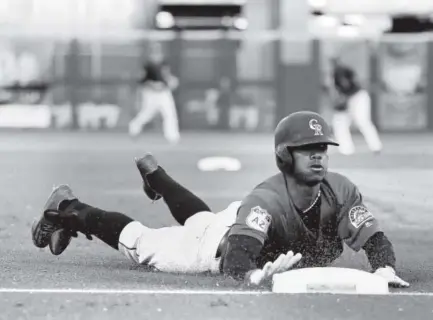  ??  ?? The Rockies’ Raimel Tapia slides into third for an RBI triple during the second inning Friday night against the San Francisco Giants. Tapia, who drove in Stephen Cardullo, then scored on Tony Wolters’ single for a 2-0 lead. Darron Cummings, The...