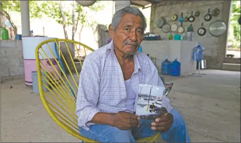  ??  ?? Wilfrido Martinez holds a photo of his 39-year-old son Mauricio, who died from covid-19 in New York, at his home in San Jeronimo Xayacatlan. Martinez said his son, who worked in a restaurant kitchen in New York, was diabetic and didn’t protect himself against infection. Until his son died, he believed the virus was a fraud perpetrate­d by politician­s for reasons he didn’t understand.
(AP/Fernando Llano)