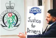  ?? AP PHOTO/FRANK AUGSTEIN ?? Uber driver and president of the App Drivers & Couriers Union Yaseen Islam poses with a poster outside the Supreme Court in London on Friday.