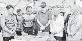  ??  ?? POTONG KEK: Tun Juhar (tengah) dan Toh Puan Norlidah (dua kanan) semasa acara memotong kek hari jadi.