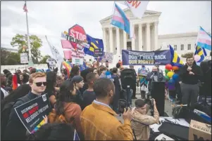  ?? The Associated Press ?? RETIREMENT OF JUSTICE: LGBT supporters gather in front of the U.S. Supreme Court, Tuesday in Washington. The Supreme Court is set to hear arguments in its first cases on LGBT rights since the retirement of Justice Anthony Kennedy. Kennedy was a voice for gay rights while his successor, Brett Kavanaugh, is regarded as more conservati­ve.