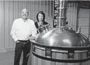  ?? [PHOTO BY TOM GILBERT, TULSA WORLD] ?? Red Fork Distillery owners Michael and Dana Hoey show off their new 250-gallon distiller. Red Fork Distillery hopes to be open by the end of the year and producing vodka, whiskey, gin and moonshine.