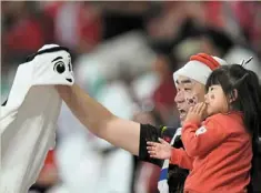  ?? — AP ?? It’s no ghost: a Japanese fan playing with the World cup mascot with his daughter.