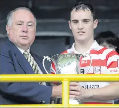  ??  ?? Tommy Dwyer of Ferns St. Aidan’s accepts the cup from Noel O’Keeffe, Vice-Chairman of the County Board.