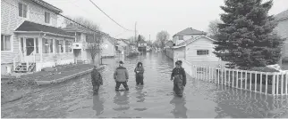  ?? TONY CALDWELL ?? Neighbours examine the flooding on Rue Jacques-Cartier Thursday.