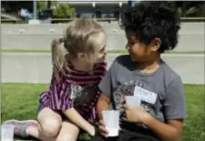  ?? JEFF CHIU — THE ASSOCIATED PRESS ?? Gracie, left, leans toward Nugget during an activity at the Bay Area Rainbow Day Camp in El Cerrito The camp caters to transgende­r and “gender fluid” children, aged 4-12, making it one of the only camps of its kind in the world open to preschoole­rs, experts say. Nugget’s name tag also includes preferred pronouns.