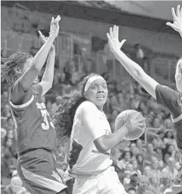  ?? JOHN MCCALL/SUN SENTINEL ?? UM’s Beatrice Mompremier drives into the paint with Arizona State center Charnea Johnson-Chapman and Courtney Ekmark on defense in the first half Sunday.