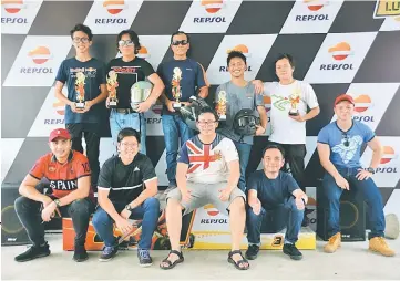  ??  ?? The racers of both categories with Abner Jerip (seated at right) and Serapi Go Karting Club president Khairul Arrifin (third right, standing) after the prize presentati­on.