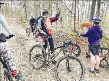  ?? (NWA Democrat-Gazette/Flip Putthoff) ?? Bob Cable talks about the history of two homesteads at Devil’s Den State Park while leading the Saturday morning family ride on April 3 along Fossil Flats Trail. Cable has attended all 32 Ozark Mountain Bike Festivals and volunteere­d at most of them.