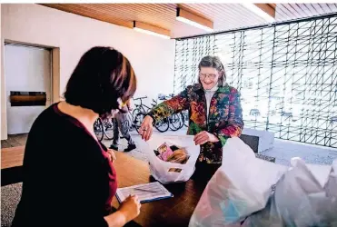  ?? FOTO: ANNE ORTHEN ?? Die Tafel an der Ulmenstraß­e in Düsseldorf ist seit Donnerstag wieder geöffnet. Silvia Giesenkirc­hen freut sich über die Lebensmitt­el, die sie bekommt.