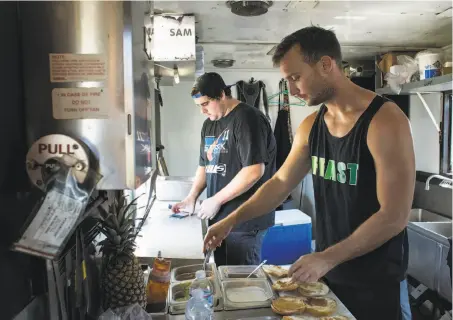  ??  ?? Above: Collin McClure, left, works with Sam Seed at A Moveable Feast in Lodi. The truck sells dishes Seed describes as upscale American street food. Below left: The truck offers a variety of specialty sandwiches. Below right: A Moveable Feast serves...