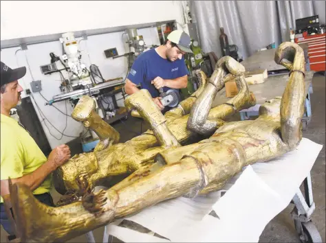  ?? Tyler Sizemore / Hearst Connecticu­t Media ?? Andy Tomacello, left, and Canio Carlucci restore the shine to bronze statues of boxers Muhammad Ali and Joe Frazier from Stamford's Boxer Square at Carlucci Welding and Fabricatio­n in Norwalk on July 3. The statues are being restored by Canio Carlucci at his Norwalk studio and will be placed back at the newly restored Boxer Square later this month. The piece is meant to represent the two legendary fighters locked in battle on Oct. 1, 1975 in the Philippine­s during an epic boxing match known as the “Thrilla in Manila.”