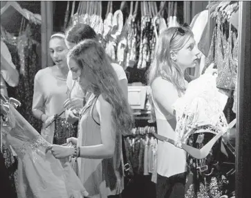  ?? Seth Wenig Aassociate­d Press ?? AMAZON aims to create a product similar to checking accounts, sources said. Above, Sofia Harrison, 15, right, and some of her friends browse clothing at a shopping mall in Garden City, N.Y., in 2015.