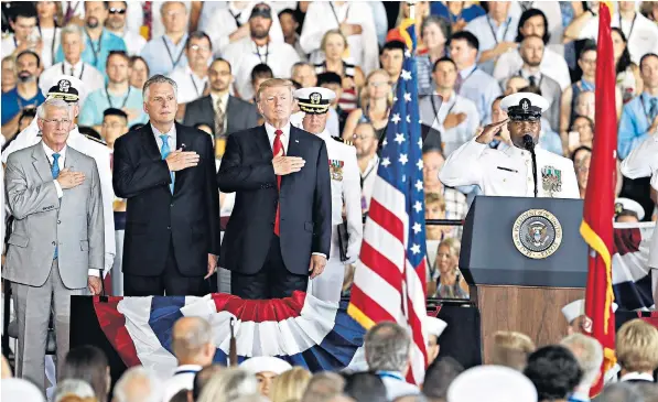  ??  ?? President Trump stands for the colours as he arrives during the commission­ing ceremony of the aircraft carrier USS Gerald R Ford at the Naval Station in Norfolk, Virginia