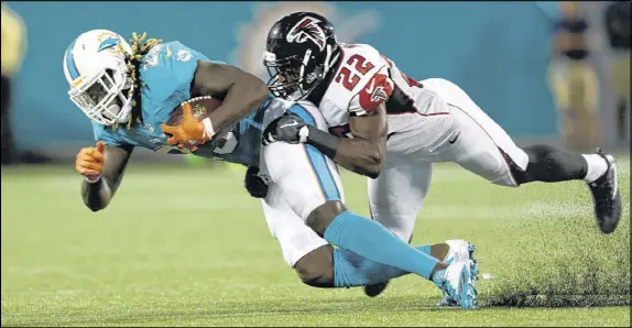  ?? WILLIE J. ALLEN JR. / AP ?? Rookie strong safety Keanu Neal (22) takes down Dolphins running back Jay Ajayi for one of his five tackles in less than a quarter of Thursday night’s 17-6 exhibition loss to Miami. Neal, a key component of Atlanta’s revamped defense, left the game...