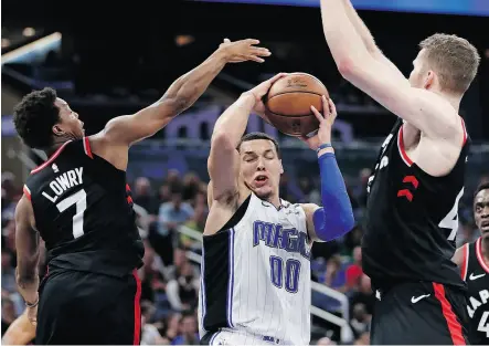  ?? JOHN RAOUX / THE ASSOCIATED PRESS ?? Orlando’s Aaron Gordon is caught between Raptors Kyle Lowry and Jakob Poeltl in Wednesday’s game.