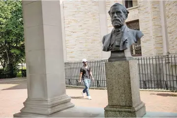  ?? — AFP photo ?? A man walks past a bust of Robert E Lee as it stands in the ‘Hall of Fame for Great Americans’ on the campus of Bronx Community College, in the Bronx borough of New York City.