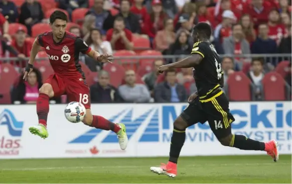  ?? CHRIS YOUNG/THE CANADIAN PRESS ?? Toronto FC’s Marco Delgado collects a pass in front of Waylon Francis of the Columbus Crew at BMO Field on Friday night. Delgado was red-carded for a tackle in the 81st minute.