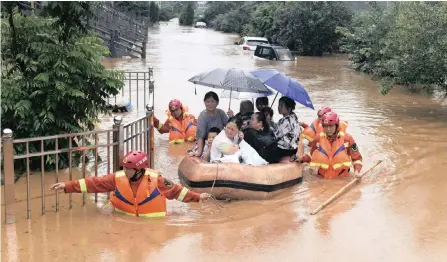  ??  ?? RESCUERS evacuate residents on a raft through flood waters in Jiujiang in central China’s Jiangxi province yesterday. Rescuers in central China were searching for people still missing in a landslide triggered amid widespread flooding across much of the country. | AP