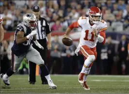  ??  ?? Steven Senne The Associated Press Kansas City quarterbac­k Alex Smith (11) scampers away from New England defensive end Trey Flowers in the first half of the Chiefs’ victory.