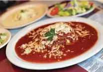  ??  ?? Lasagna brings comfort in layers for troubled times, like this traditiona­l meat-and-tomato-sauce lasagna at Capparelli's.