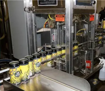  ??  ?? Ready to go: Cans rolling off the production line at the 12 Acres Brewing Company microbrewe­ry housed in a converted sheep shed on the McDonalds’ farm