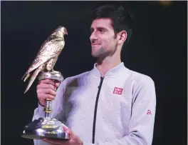  ??  ?? DOHA: Serbia’s Novak Djokovic poses with the winner’s trophy after beating Britain’s Andy Murray during their final tennis match at the ATP Qatar Open in Doha yesterday. — AFP