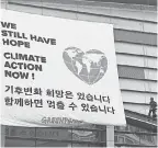  ?? JUNG YEON-JE/AFP/GETTY IMAGES ?? Greenpeace activists display a banner outside a conference of the Intergover­nmental Panel for Climate Change in Incheon, South Korea, on Monday.