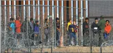  ?? JOSE LUIS GONZALEZ / REUTERS ?? Migrants gather near the fence on the US-Mexico border in Ciudad Juarez, Mexico, on Tuesday as they wait to be processed by US Border Patrol in El Paso, Texas.