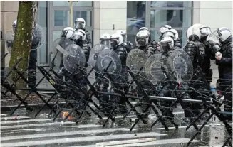  ?? Picture: YVES HERMAN/ REUTERS ?? UNDER PRESSURE: Police officers stand guard during a European farmers’ protest over price pressures, taxes and green regulation on the day of an EU agricultur­e ministers meeting in Brussels, Belgium, yesterday