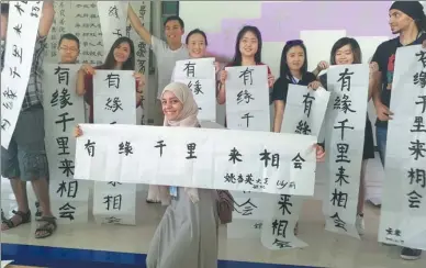  ?? HUO YAN / CHINA DAILY ?? Students from Southeast Asian countries show their calligraph­y works at Qinzhou University in the Guangxi Zhuang autonomous region in June.