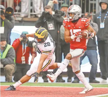  ?? JOSEPH MAIORANA/USA TODAY SPORTS ?? Ohio State wide receiver Chris Olave catches a touchdown against Michigan during the second quarter at Ohio Stadium.