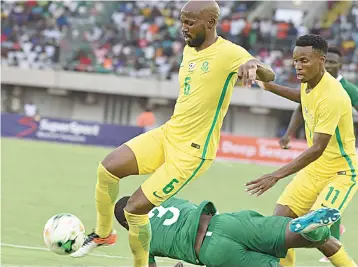  ??  ?? Nigeria’s Elderson Echiejile tumbles under pressure from South African defender Mphahlele Ramahlwe (left) during the 2019 African Cup of Nations qualifying match at the Godswill Akpabio Stadium