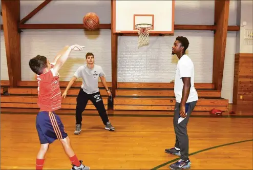  ?? Ned Gerard / Hearst Connecticu­t Media ?? Guards Joey Calcaterra, center, and Nahiem Alleyne of the UConn men’s basketball team work with summer campers during a visit to the Wakeman Boys & Girls Club in Fairfield on Monday.