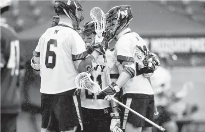  ?? PHIL HOFFMAN/CAPITAL GAZETTE ?? Navy freshman Jon Jarosz, left, celebrates with junior Nick Cole, center, and freshman Dane Swanson after Cole scored a goal during Sunday’s game against Jacksonvil­le in Annapolis. Navy won 13-6 to improve to 2-0 on the season.