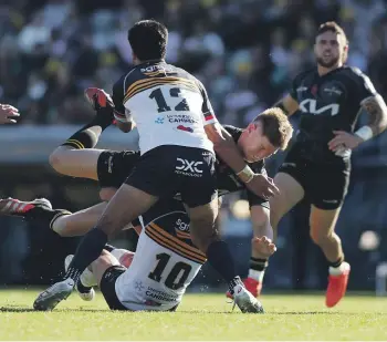  ?? GETTY ?? Hurricanes midfielder Jordie Barrett is halted by Noah Lolesio and Tamati Tua in Canberra yesterday.