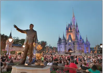 ?? (AP/John Raoux) ?? Crowds are shown in January at the Magic Kingdom theme park at Walt Disney World in Lake Buena Vista, Fla. Disney said in a statement that extra hand sanitizers were being placed throughout its theme parks and hotels.