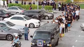 ?? PIC BY MIKAIL ONG ?? Attendees forming a long procession as Goh Xin Xi’s casket is taken to Mount Erskine Cantonese Cemetery in a hearse.