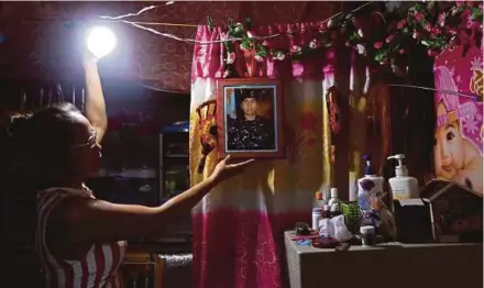  ?? REUTERS PIC ?? A woman showing a picture of her son, a soldier killed during the battle against militants in Marawi, on Mindanao island, inside her shanty in Navotas, Manila. The Marawi battle could alter the way terrorism in Southeast Asia would be conducted and the...