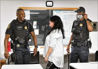  ?? PHOTOS BY HYOSUB SHIN/HYOSUB.SHIN@AJC.COM ?? Deputy Shannon Volkodav (center), Gwinnett County Sheriff’s Office public informatio­n officer, greets Deputy Patrick Edmond (left) and Deputy Warren Hobbs at the Gwinnett jail last month. In a matter of weeks over the summer, the two men had life-threatenin­g medical emergencie­s in the jail, and inmates came to their aid. “It’s easy to assume there’s an adversaria­l relationsh­ip with officers and criminals, but these incidents prove that’s not always the case,” Volkodav said.