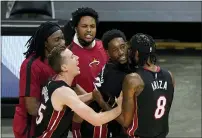  ?? WILFREDO LEE — THE ASSOCIATED PRESS ?? Heat center Bam Adebayo, second from right, is mobbed by teammates after he made the winning shot against the Nets Sunday in Miami.