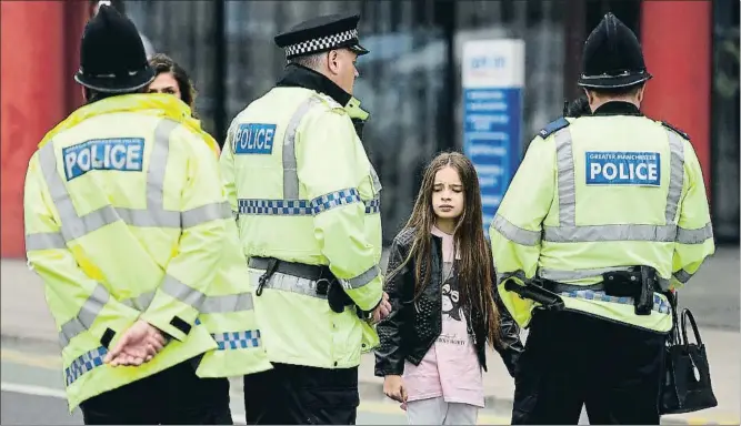  ?? OLI SCARFF / AFP ?? Una niña con una camiseta de la cantante Ariana Grande, cerca del lugar del atentado, acordonado por la policía