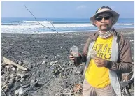  ??  ?? Wayan Aksara, chairman of Trash Hero Indonesia, picks up plastic cups at Saba Beach in Gianyar, Bali.