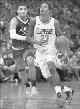  ?? Photograph­s by David Zalubowski Associated Press ?? LOU WILLIAMS of the Clippers drives to the basket ahead of Gary Harris of the Denver Nuggets in the first half. Williams finished with a game-high 25 points.