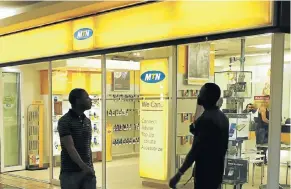  ?? Picture: Reuters ?? People walk past an outlet of SA’s MTN Group in downtown Cape Town. Efforts to regulate competitio­n in the market may hinder the developmen­t of networks, critics say.