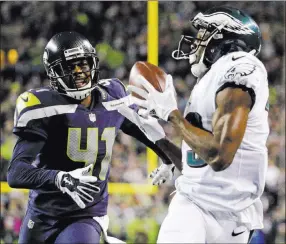  ?? Ted S. Warren ?? The Associated Press Philadelph­ia’s’ Nelson Agholor snares a pass for a TD, beating Seattle’s Byron Maxwell.
