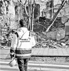  ?? — AFP photo ?? A worker stands near a damaged building in Zafferana Etnea near Catania.