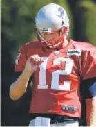  ?? Steven Senne, The Associated Press ?? New England Patriots quarterbac­k Tom Brady pauses to look at his hand during practice Tuesday.