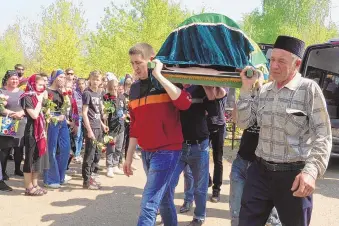 ?? DMITRI LOVETSKY/ASSOCIATED PRESS ?? Men carry the coffin of Elvira Ignatieva, an English teacher killed in a shooting Tuesday at a school in Kazan, Russia. Seven students and two employees died in the attack.